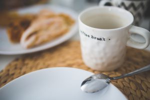 Weiße Tasse mit Aufschrift "coffee break"